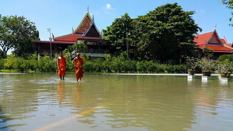 น้ำท่วมแหล่งท่องเที่ยวที่สุพรรณฯ วัดดังต้องปิดรับ นทท.ให้อาหารปลา