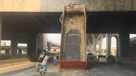 วุ่น! ดัมพ์เด้งเอง ชนหลุดคาสะพานทางด่วน ทำรถติดสาหัส 