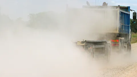 ชาวบ้านต้องทนสูดดมฝุ่นจากรถบรรทุกหินดินทรายที่ไม่มีผ้าใบคลุม