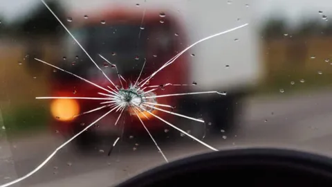 กระจกโดนหินดีดใส่แตก ขับยังไงไม่ให้โดนอีก?