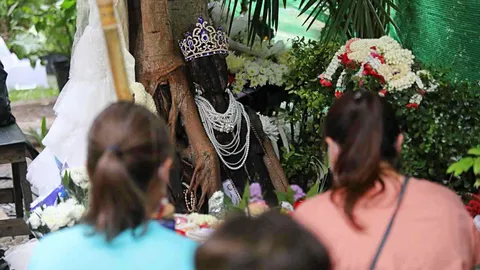 คอหวยคึกคัก แห่ต่อคิวรอขอ "เลขเด็ดงวดนี้" จาก "พี่สาว" หุ่นไม้ใต้ต้นโพธิ์