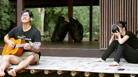  เวียร์ ศุกลวัฒน์ นั่งดีดกีตาร์ร้องเพลง วิกกี้ รับบทช่างภาพเก็บบรรยากาศ