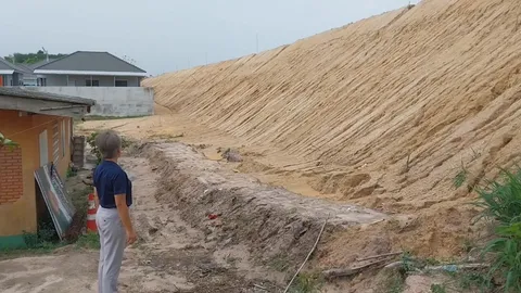 สั่งหยุดการก่อสร้าง นายทุนถมที่สูงมิดหลังคาชาวบ้าน พบไม่มีการยื่นขออนุญาต