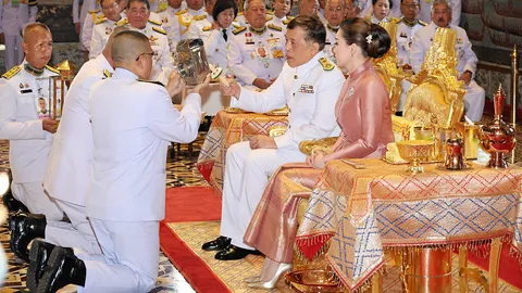 ในหลวง ทรงจุดเทียนชนวนพระราชทานแก่ พล.อ.ท.ภักดี แสง-ชูโต รักษาราชการ แทน ผอ.กองพระราชพิธี
