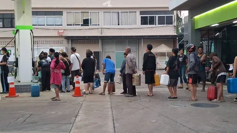 สุโขทัย ชาวบ้านแห่หิ้วแกลลอนต่อคิวรอซื้อน้ำมันดีเซล แม้ราคาขยับแตะลิตรละ 33 บาท
