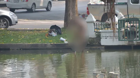 หญิงนิรนามสวมทูพีซ ยืนอาบน้ำริมคูเมืองเชียงใหม่