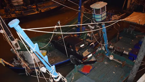 เก๋งบีเอ็มยางแตก หล่นสะพานเมืองชล โชคดีค้างบนเรือไดหมึก