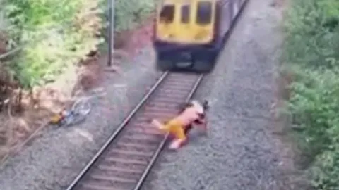 ชมคลิป ฮีโร่ช่วยคนเมา หวิดโดนรถไฟชนแหลก ชาวเน็ตบางส่วนเชื่อตัดต่อ