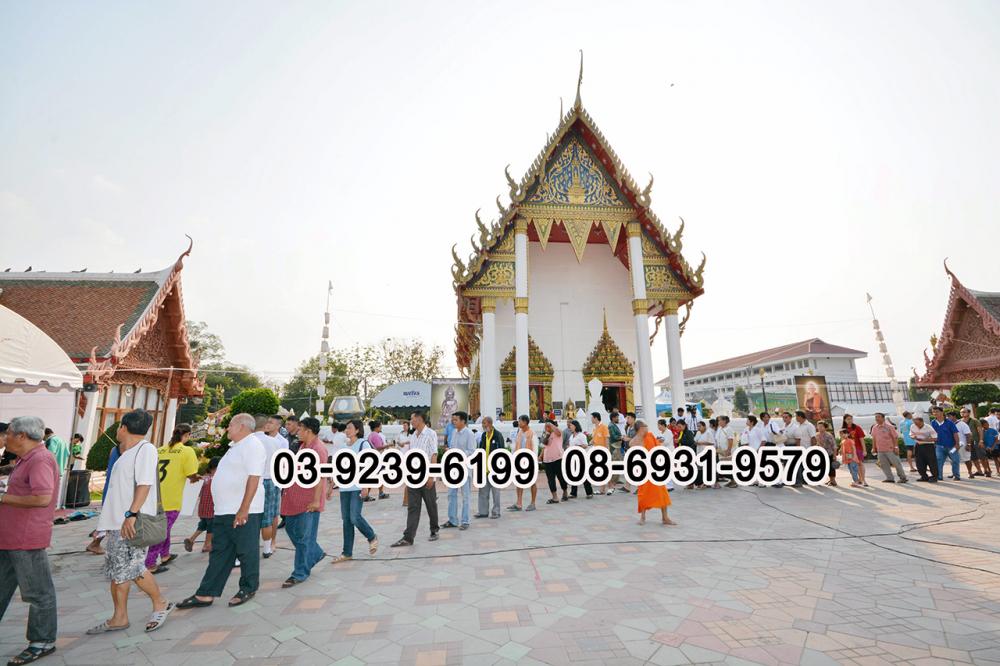 ผู้คนเข้าแถวรอรับวัตถุมงคลที่ลานวัดท่าหลวง.