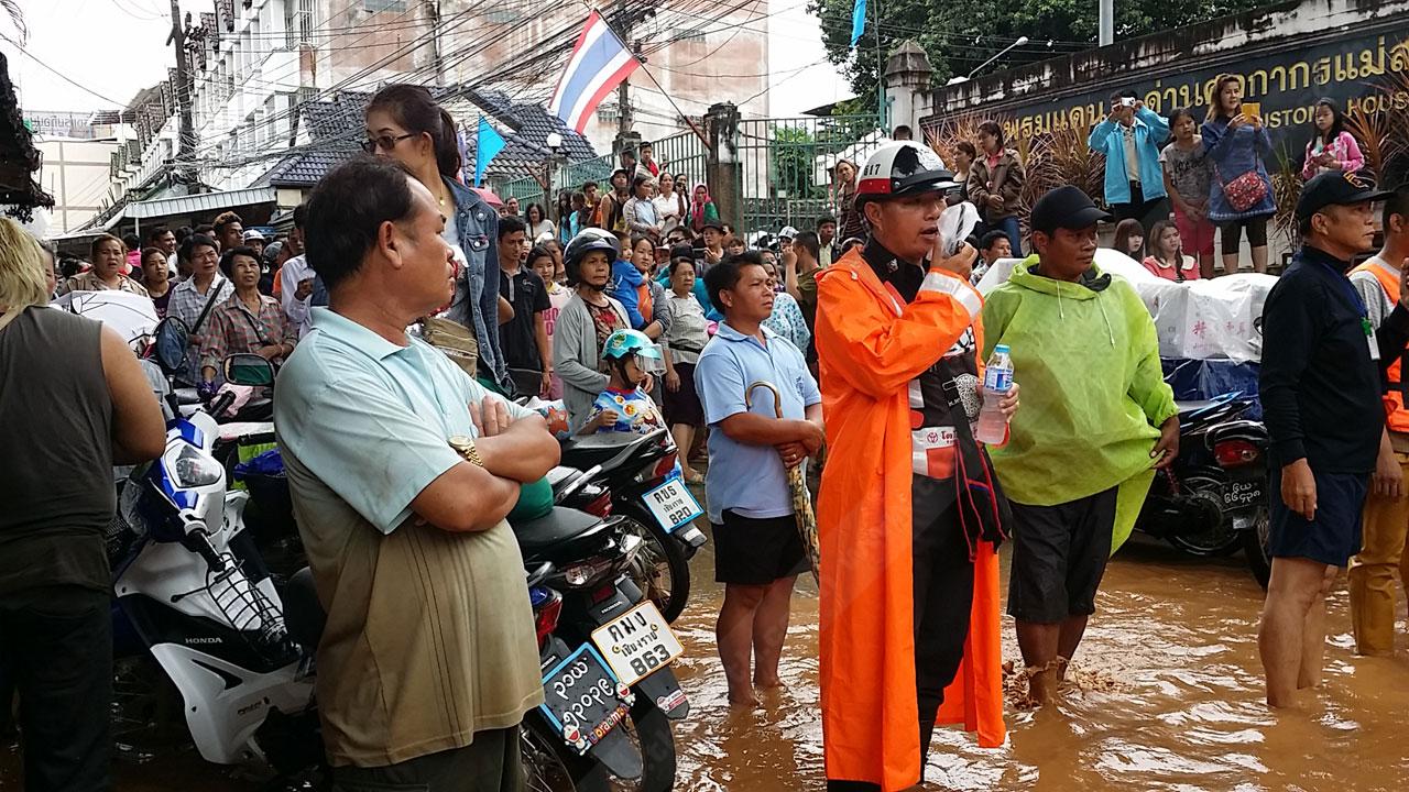 ชาวบ้านจับกลุ่มดูสถานการณ์ และฟังการประกาศจากเจ้าหน้าที่