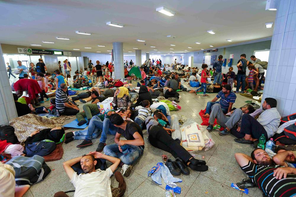 ผู้อพยพพักผ่อนบริเวณทางเดินใต้ดินใกล้สถานีรถไฟเคเลตี หลังจากประท้วงข้ามวันข้ามคืนจนเหนื่อยล้า (ภาพ: REUTERS)