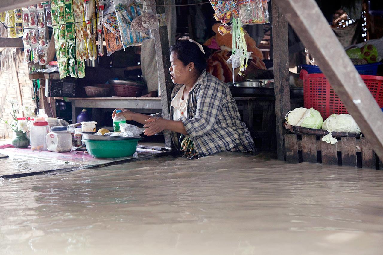 แม่ค้าต้องค้าขายทั้งๆที่น้ำท่วม (ภาพ: AP)