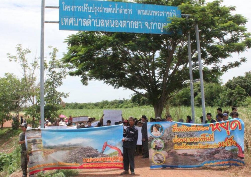 ชาวบ้านหนองตากยา 100 กว่าคน เดินมาชุมนุมยืนถือป้ายเขียนข้อความคัดค้านไม่เอาขยะ