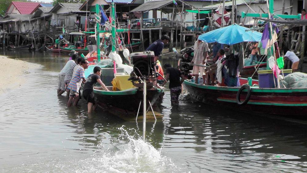 ชาวประมงพื้นบ้านรอให้น้ำขึ้นสูงสุด แล้วยังต้องช่วยกันเข็นเรือเพื่ออกทะเล