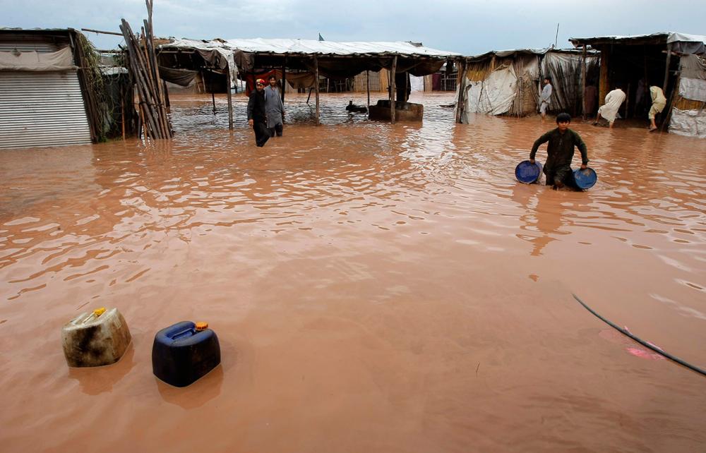 ชาวปากีสถานเก็บของออกจากบ้านที่ถูกน้ำท่วม (ภาพ: AP)