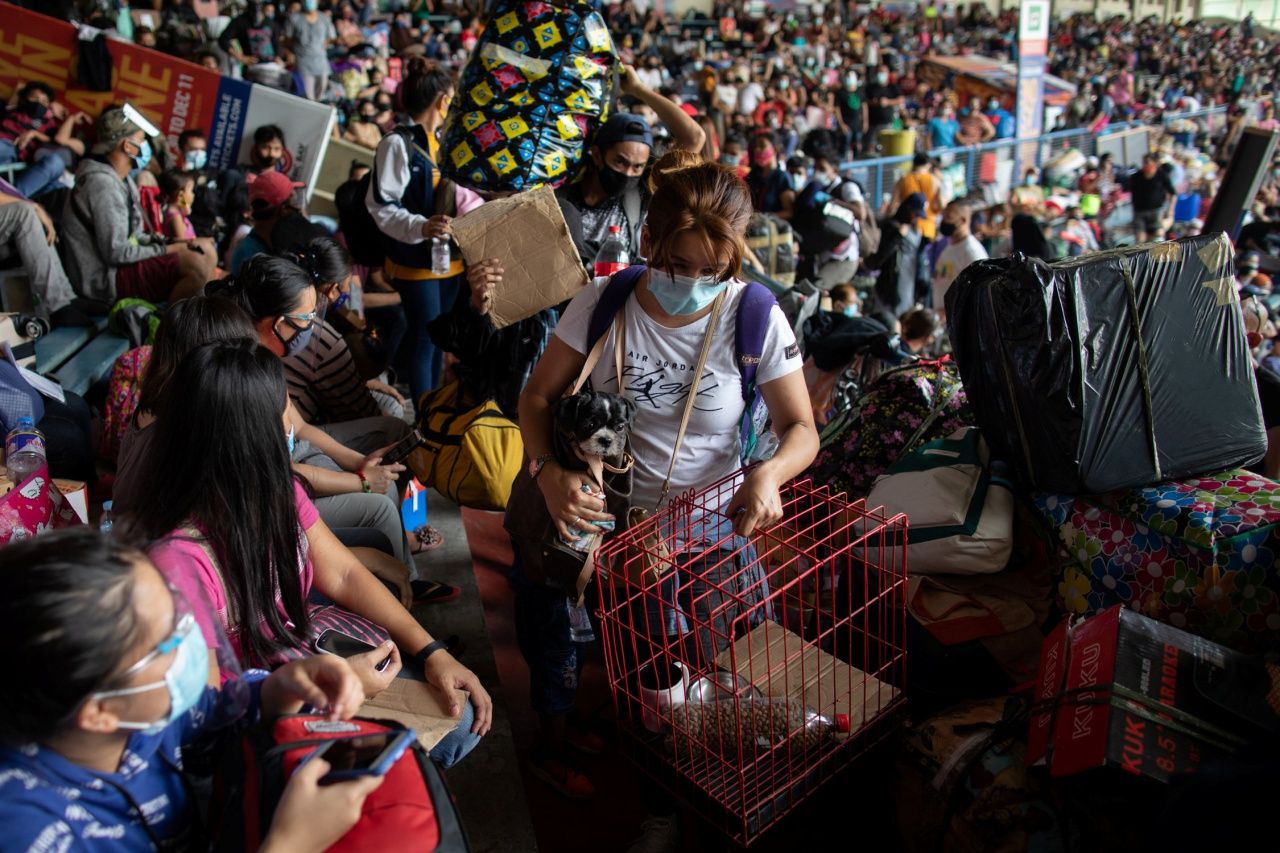 ชาวฟิลิปปินส์มายังสนามกีฬาในกรุงมะนิลา เมื่อ 25 ก.ค. จนแน่นขนัด เพื่อรอขึ้นรถโดยสารที่รัฐบาลจัดหาให้ในการเดินทางจากกรุงมะนิลา กลับบ้านเกิด ขณะกำลังเชื้อโควิด-19 กำลังระบาดอย่างหนัก