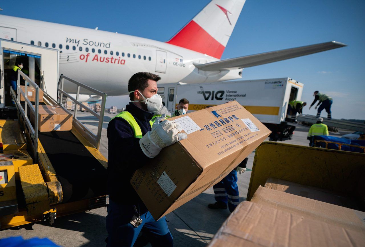 เจ้าหน้าที่ออสเตรียกำลังลำเลียงชุดป้องกันที่ขนมาจากประเทศจีน เพื่อส่งไปอิตาลี