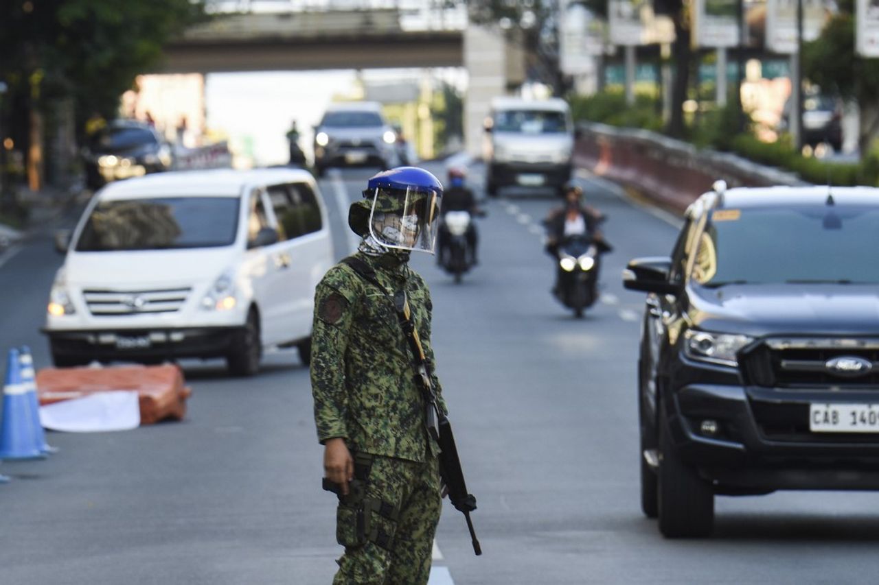 ทหารฟิลิปปินส์ยืนประจำการที่จุดตรวจในกรุงมะนิลา ขณะที่รัฐบาลประกาศใช้มาตรการกักกัน ควบคุมการระบาดของโควิด-19