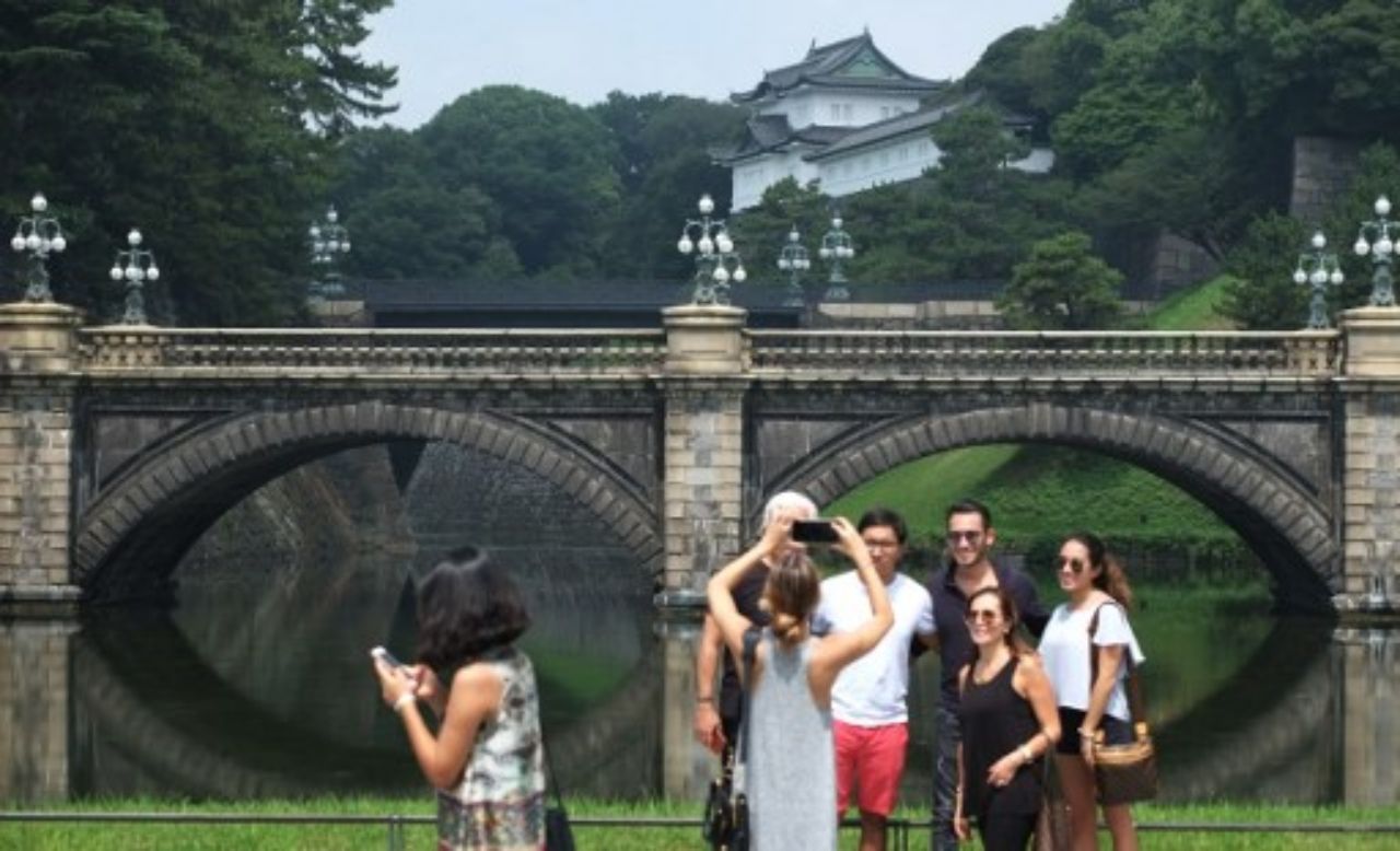 นักท่องเที่ยวถ่ายรูปอยู่ด้านหน้าพระราชวังอิมพีเรียล ในกรุงโตเกียว