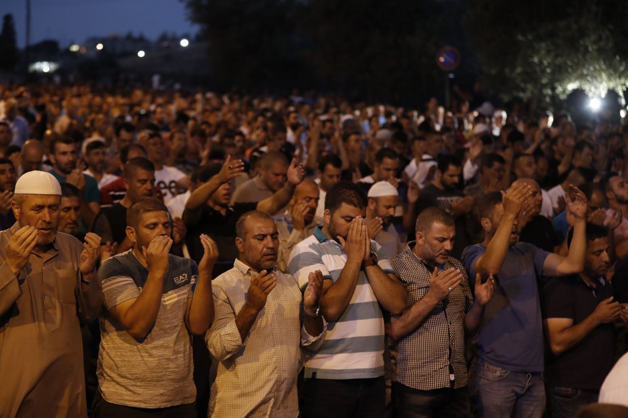 ผู้ชุมนุมชาวมุสลิมปาเลสไตน์สวดมนต์หน้าประตูสิงห์ (Lions' Gate) ทางเข้าหลักของมัสยิด อัล-อัคซา ในเขตเมืองเก่าของกรุงเยรูซาเลม