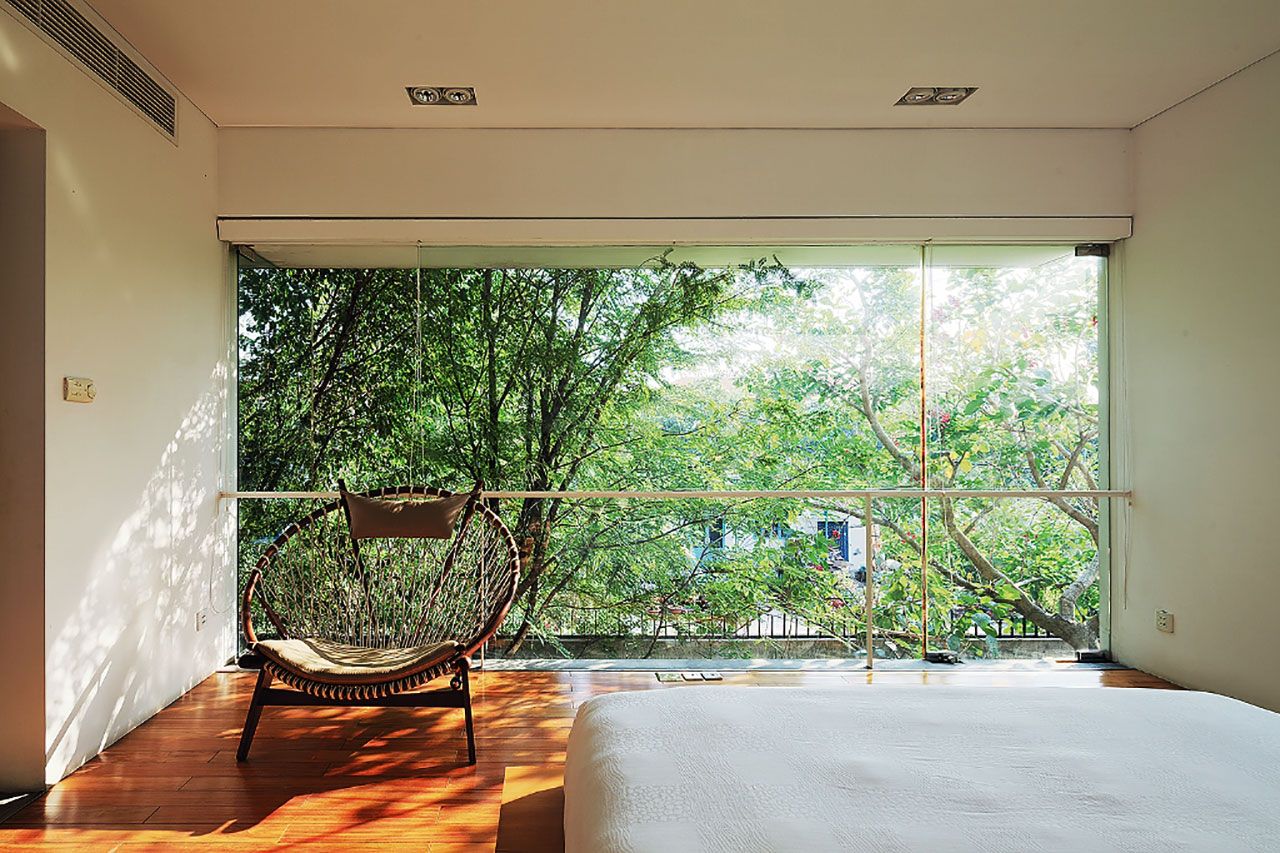 ออกแบบผนังห้องนอนเป็นผนังกระจกใสยาวทั้งผืนเพื่อดึงแสงธรรมชาติจากภายนอกเข้ามาภายใน โดยยังมองเห็นทิวทัศน์ของร่มเงาต้นไม้รอบๆ สร้างบรรยากาศสบายๆ เหมือนอยู่ใต้ร่มไม้