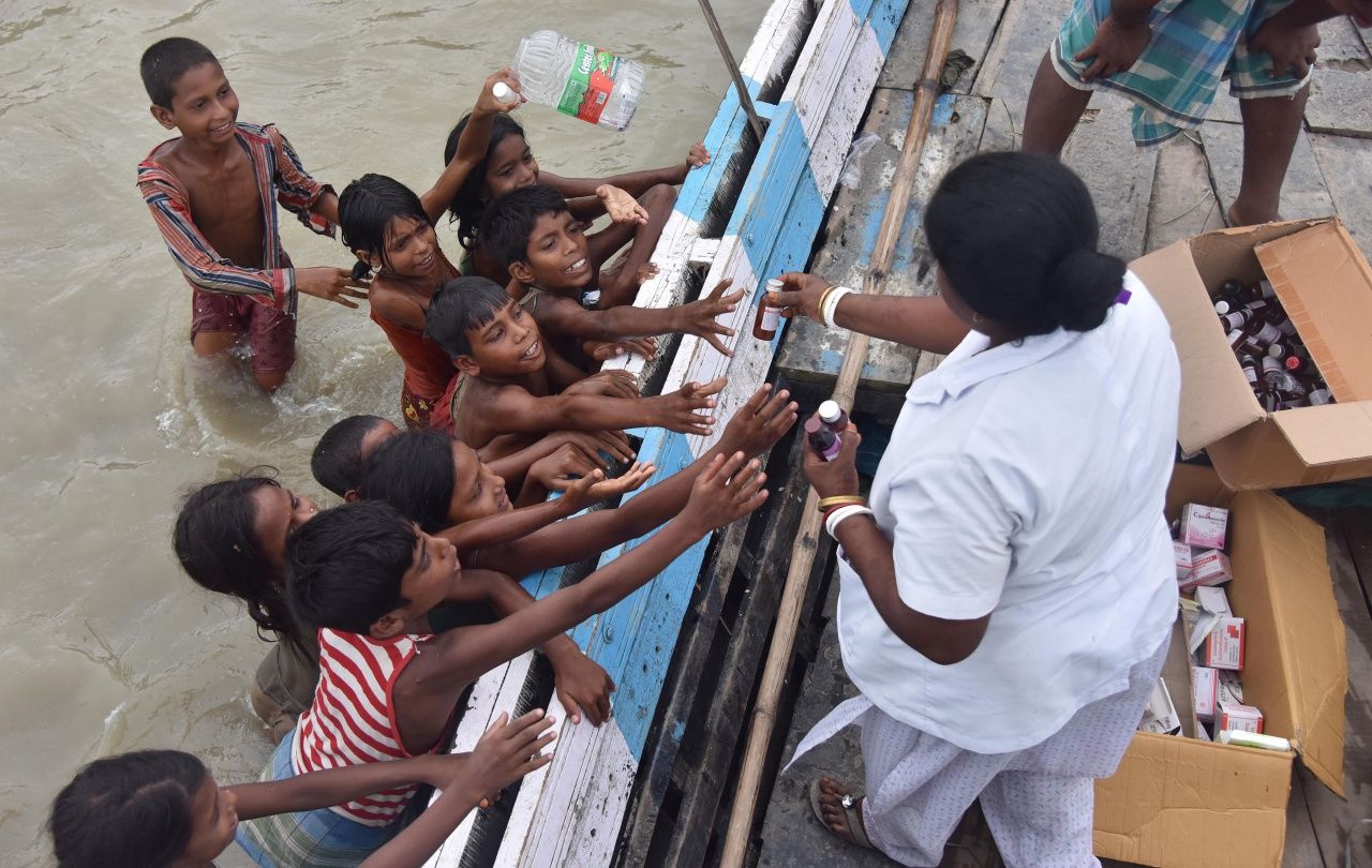 เด็กชาวอินเดียในรัฐอัสสัมรอรับยาจากเจ้าหน้าที่การแพทย์