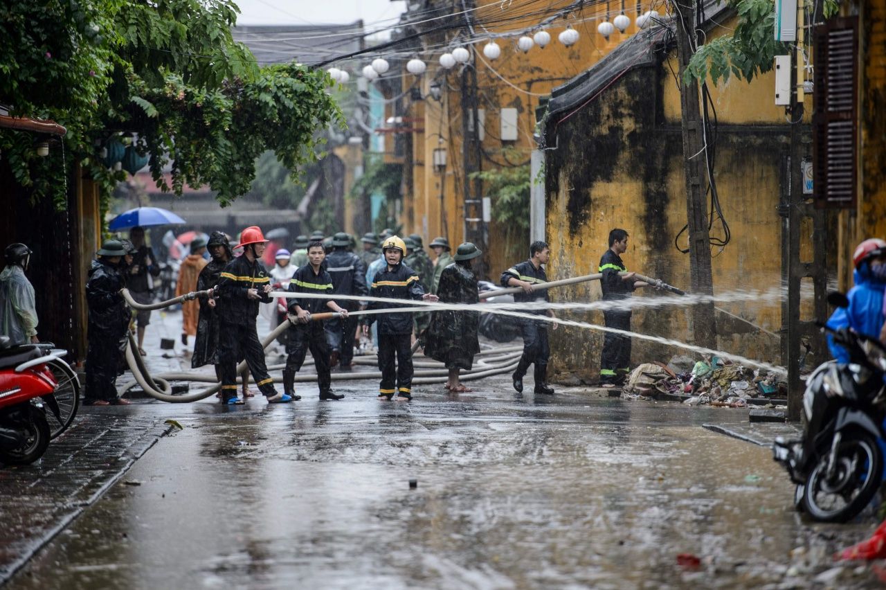เจ้าหน้าที่ฉีดน้ำไล่โคลนออกจากถนนในเมืองฮอยอัน