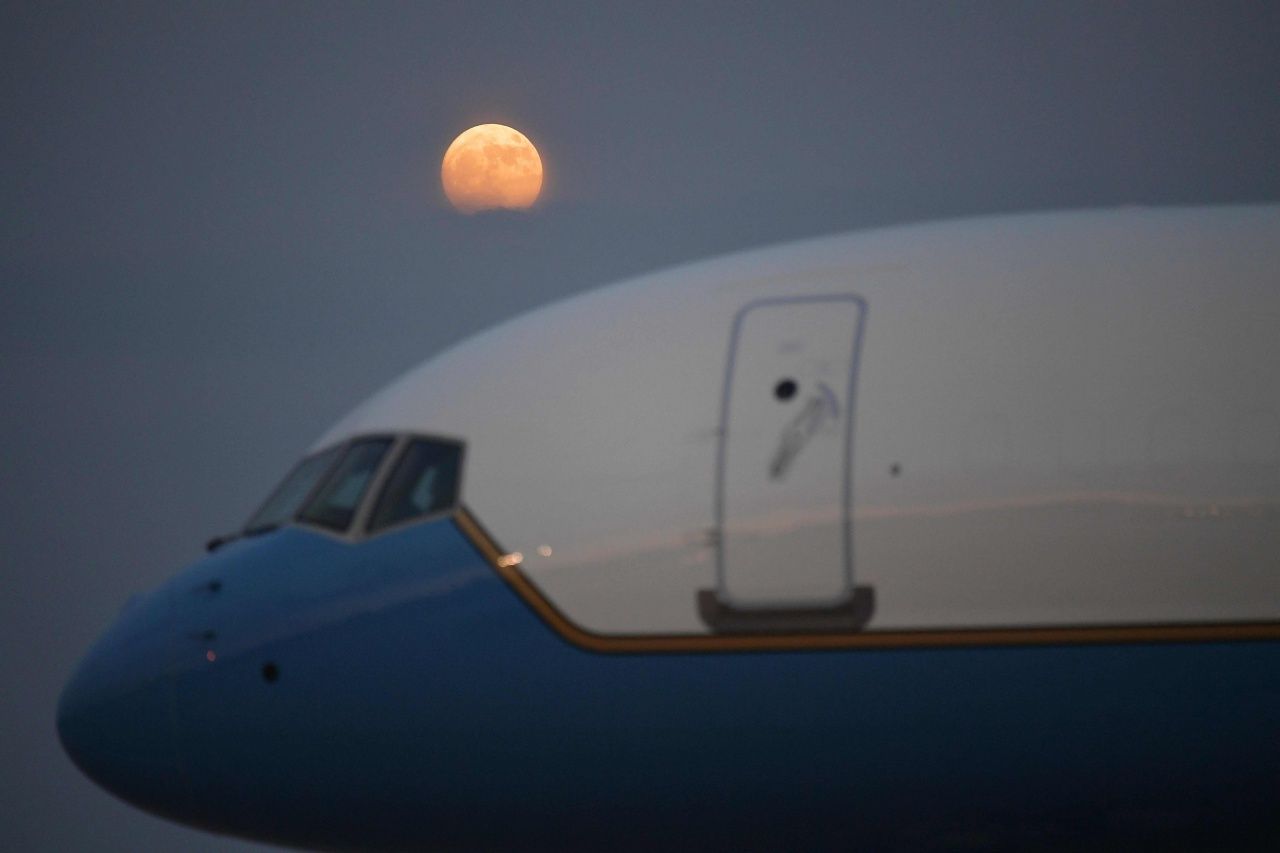 พระจันทร์เต็มดวงถูกเมฆบดบังเล็กน้อย ขณะลอยเหนือเครื่องบิน แอร์ ฟอร์ซ วัน ที่ฐานทัพอากาศ แอนดรู