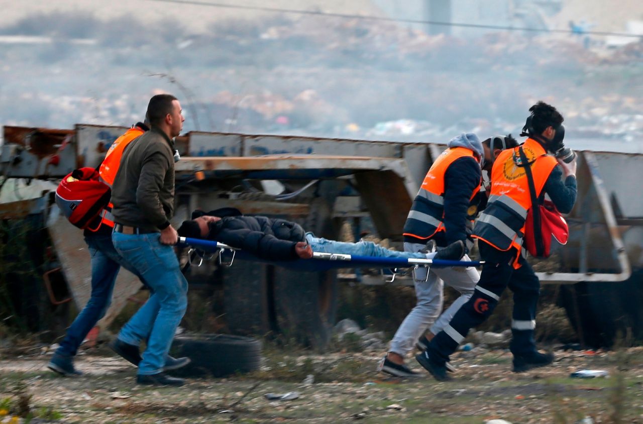 เจ้าหน้าที่หน่วยฉุกเฉินขนย้ายผู้บาดเจ็บการเหตุปะทะระหว่างผู้ประท้วงกับทหารอิสราเอลออกจากพื้นที่