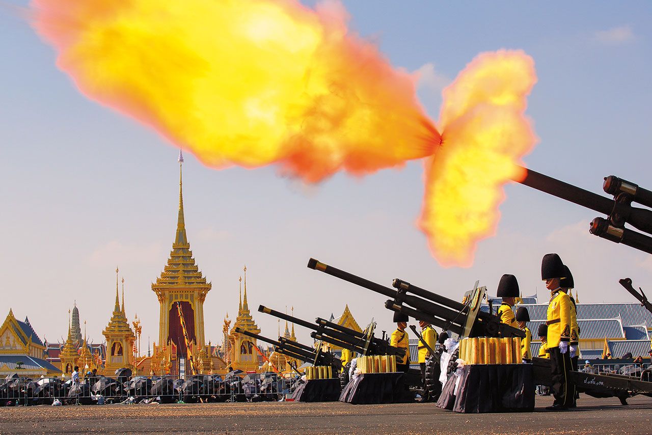 ทหารปืนใหญ่ยิงสลุตเพื่อถวายพระเกียรตินาทีละหนึ่งนัด ขณะอัญเชิญพระโกศทองใหญ่ออกจากพระบรมมหาราชวังไปเทียบยังพระมหาพิชัยราชรถหน้าวัดพระเชตุพนวิมลมังคลาราม และเริ่มยิงปืนใหญ่ต่อเนื่องนาทีละหนึ่งนัดอีกครั้ง เมื่อริ้วขบวนพระบรมราชอิสริยยศเคลื่อนไปยังพระเมรุมาศท้องสนามหลวง จนกระทั่งพระโกศทองใหญ่ขึ้นประดิษฐานบนพระจิตกาธานในพระเมรุมาศแล้วจึงหยุดยิง