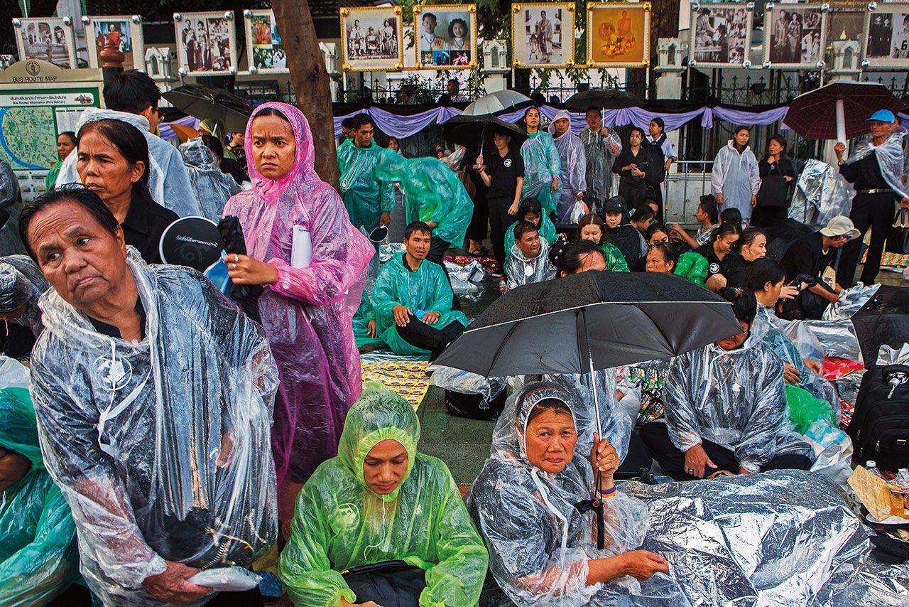 แม้ฝนจะกระหน่ำลงมาอย่างหนัก แต่ประชาชนบริเวณหน้ามหาวิทยาลัยธรรมศาสตร์ก็ยังยืนหยัดไม่ยอมหลบฝน เพื่อเข้าร่วมพระราชพิธีถวายพระเพลิงพระบรมศพและแสดงความอาลัยแด่ในหลวงรัชกาลที่ 9 เป็นครั้งสุดท้าย