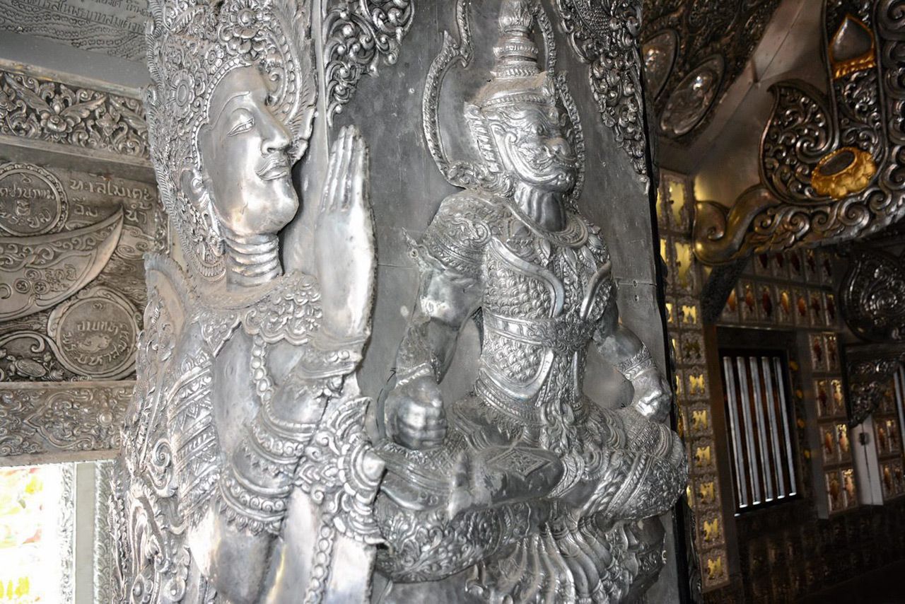 องค์เทพในตำนานแกะสลักด้วยเงินวาววับสวยงามบนผนังหอศิลป์.