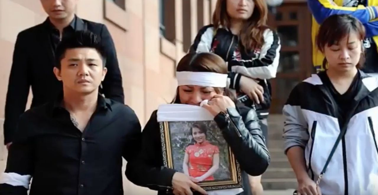 พี่สาวถือรูปของนางสาวเกวี่ยน เหวียน  มาขึ้นศาลด้วยความสะเทือนใจ