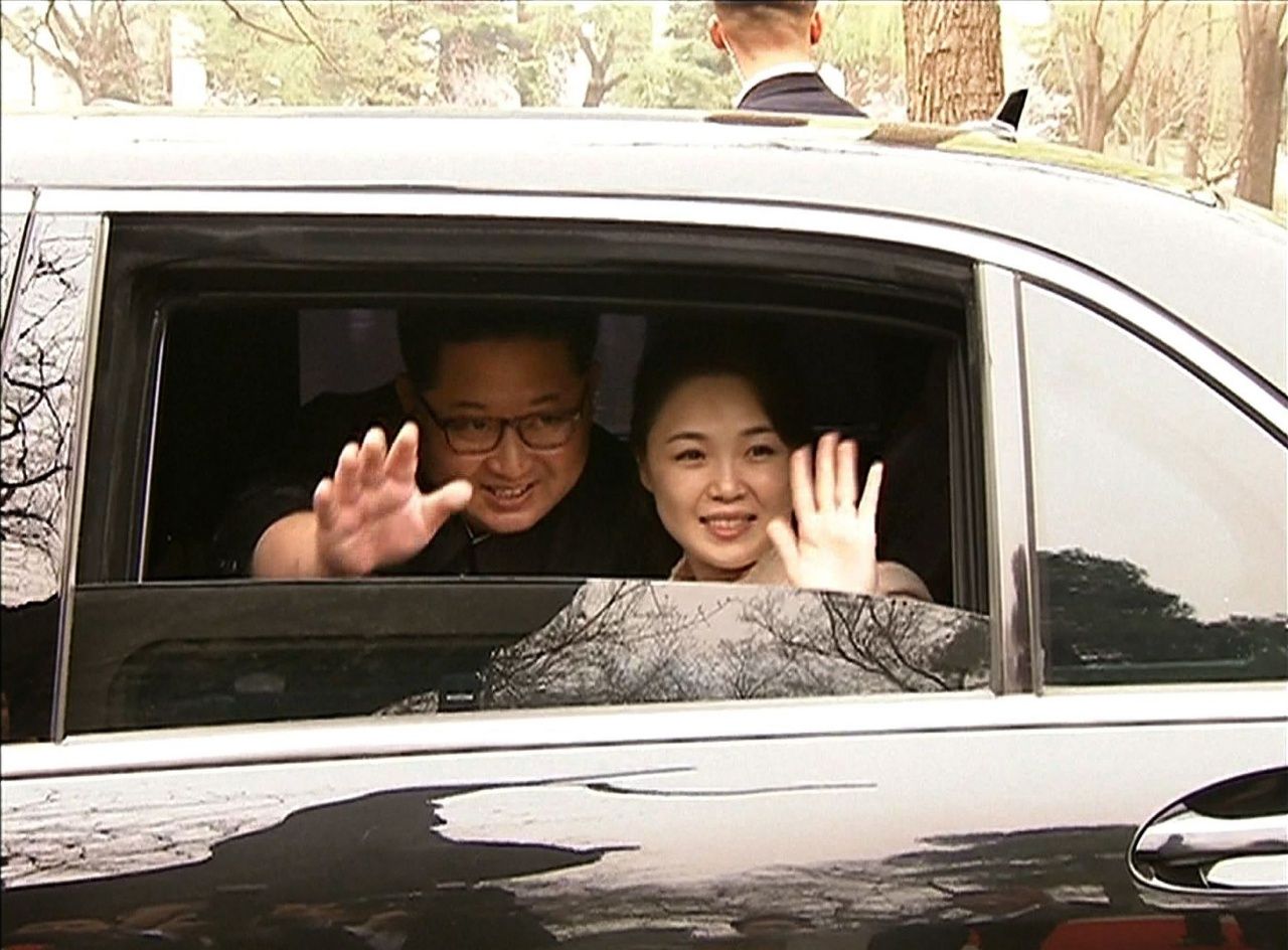 คิม จอง-อึน และนาง รี ซอล จู ภริยา โบกมือลาเจ้าหน้าที่จีน