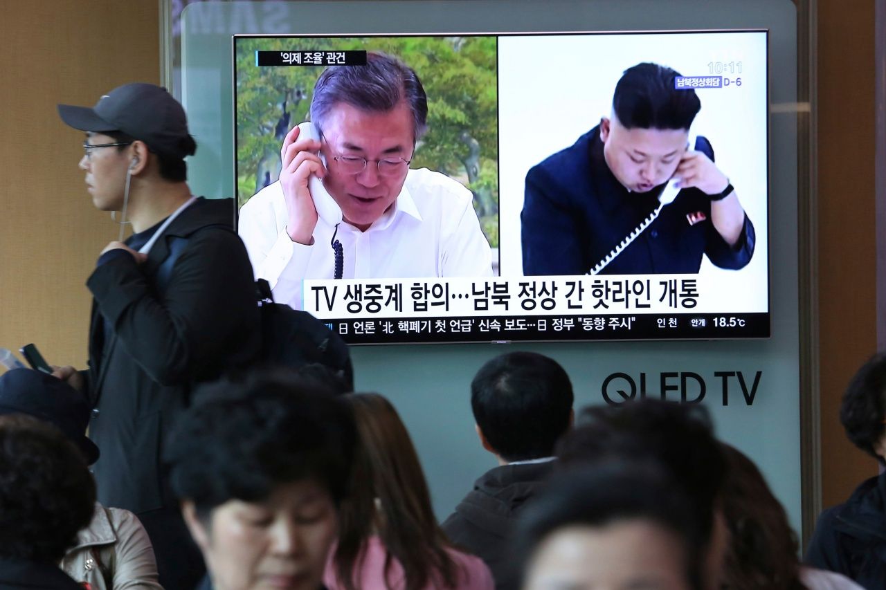 ภาพนายมูน แจ-อิน กับนาย คิม จอง-อึน ฉายบนจอโทรทัศน์ในเกาหลีใต้