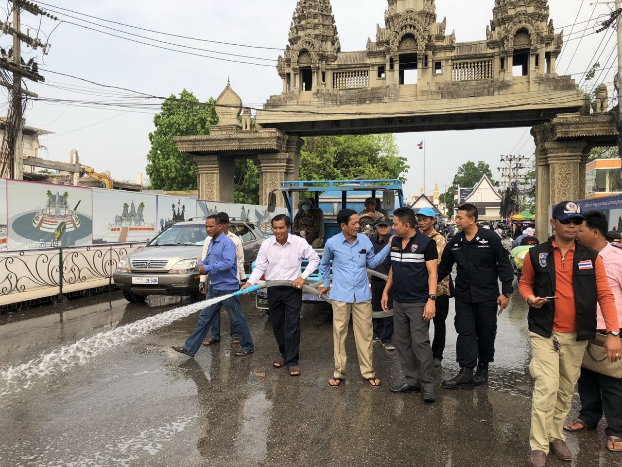 (พ.ต.อ.เบญจพล รอดสวาสดิ์ ผกก.ตม.จว.สระแก้ว ร่วมกับนายซาน เซียน โฮ ผู้ว่าราชการกรุงปอยเปต (เสื้อแขนยาว) ช่วยกันระดมฉีดน้ำล้างถนนและสะพานมิตรภาพไทย-กัมพูชา )