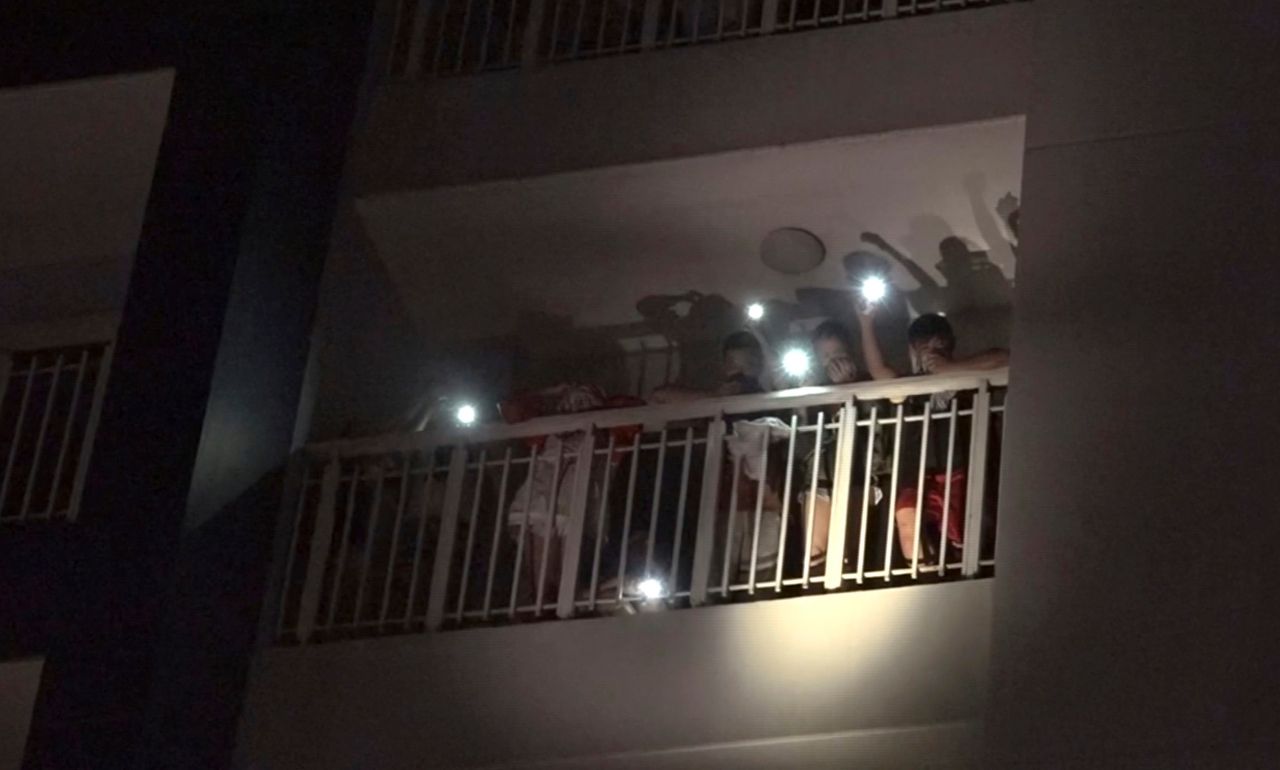 ผู้คนที่พักอยู่ที่คอนโดมิเนียม ใช้ไฟฉายจากมือถือ ขอความช่วยเหลือจากทีมกู้ภัย-ดับเพลิง