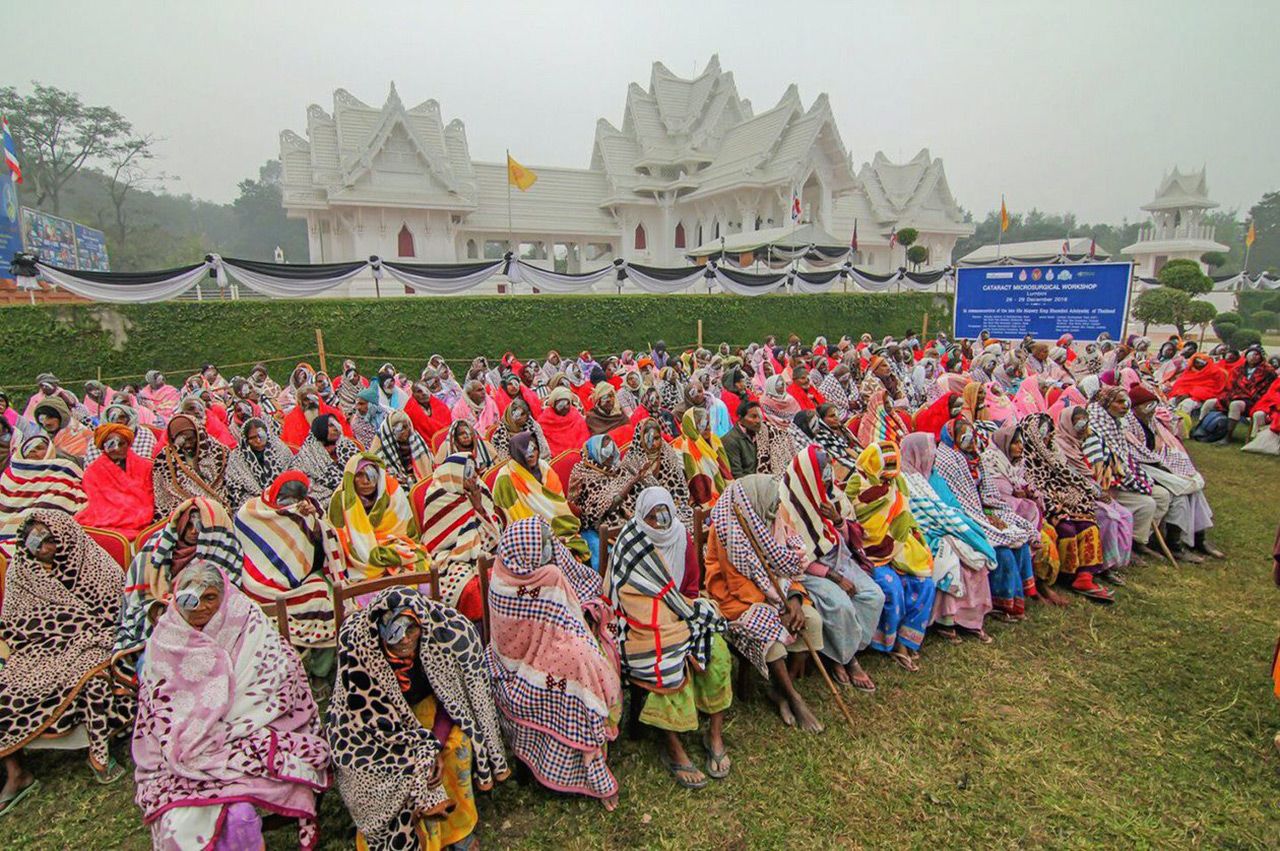ชาวเนปาลที่ได้รับการผ่าตัดจากคณะแพทย์ไทยและเนปาล มานั่งรอการตรวจและเปิดผ้าปิดตา ที่สนามของวัดไทยลุมพินี.