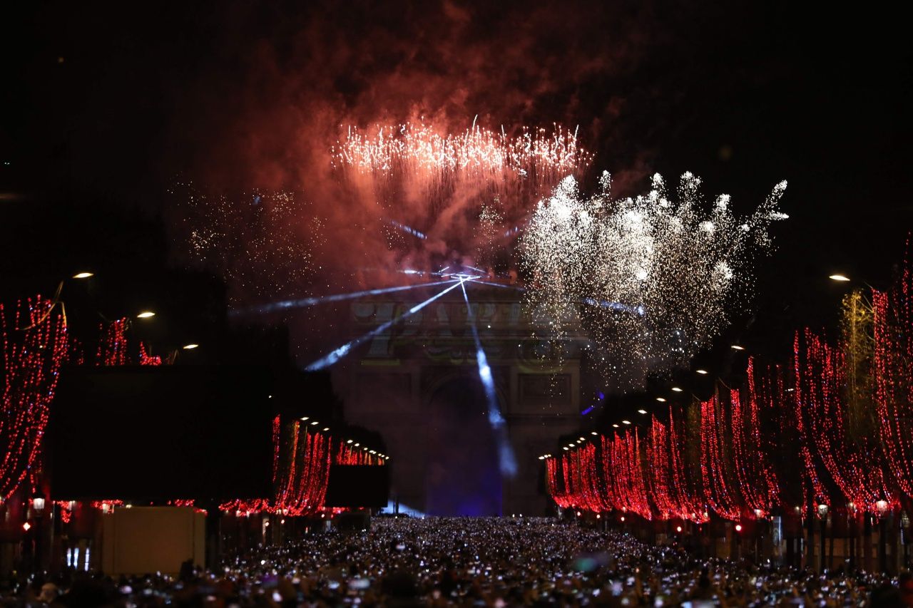 ถนนฌ็องเซลิเซ่ ในกรุงปารีส ประดับประดาด้วยแสงไฟสวยงาม ขณะที่ชาวฝรั่งเศสชมดอกไม้ไฟฉลองปีใหม่ซึ่งจุดที่ประตูชัยฝรั่งเศส