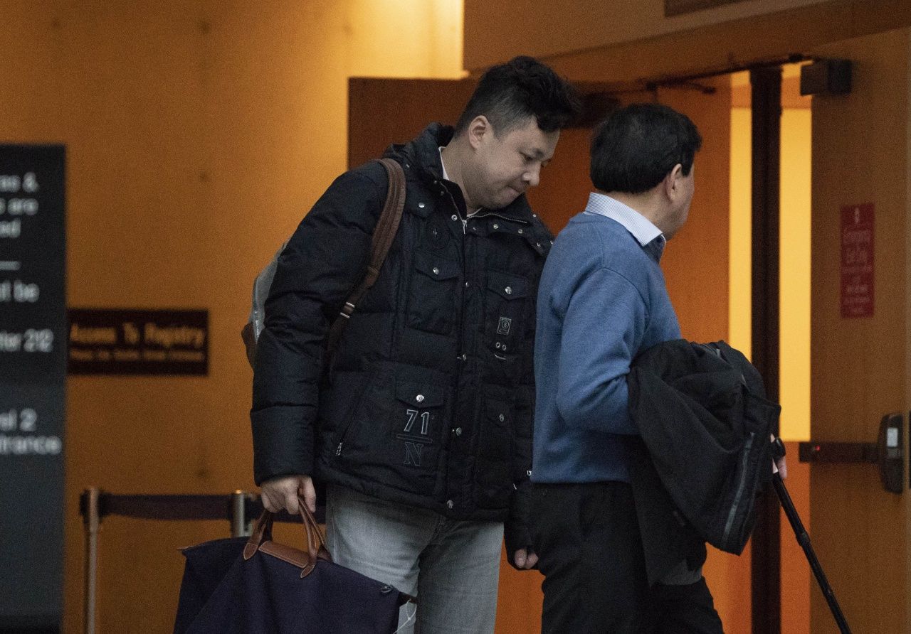 นายหลิว เสี่ยวซ่ง (ซ้าย) สามีของนางสาวเหมิง หวันโจว ขณะไปที่ศาลในนครแวนคูเวอร์