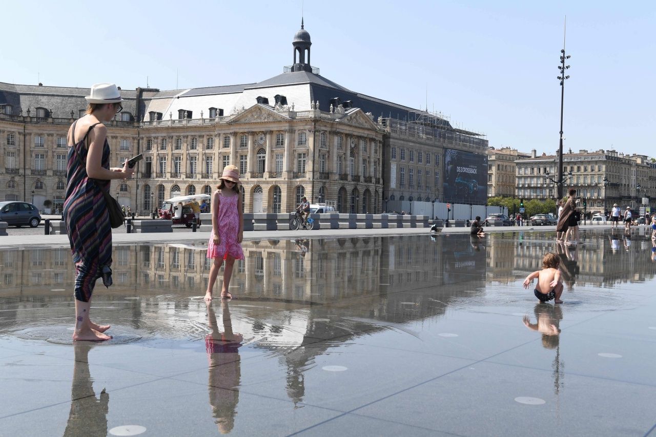 ผู้ปกครองพาเด็กๆ ลูกหลานมาเล่นน้ำที่ลานด้านหน้า Place de la Bourse ในเมืองบอร์กโดซ์ ของฝรั่งเศส เนื่องจากสภาพอากาศร้อนจัด