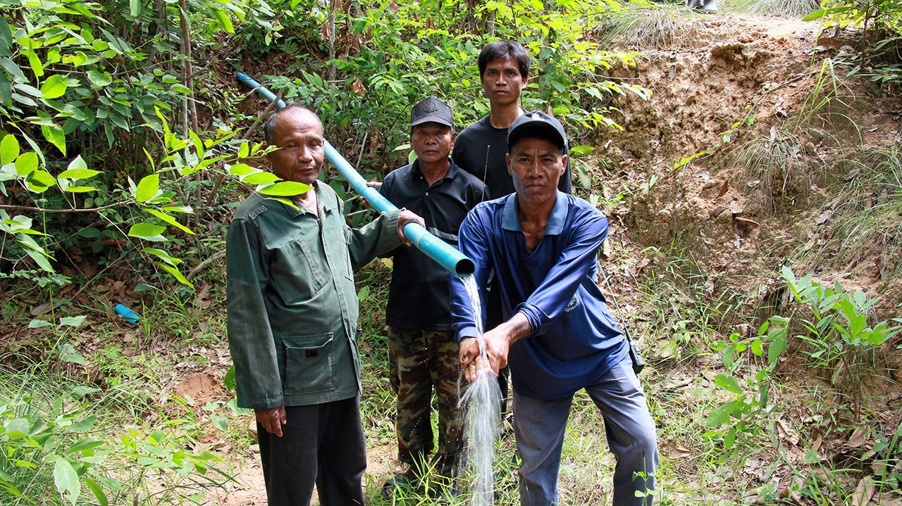 หลังวางท่อเสร็จน้ำจากเทือกเขาพนมดงรักไหลมาตามท่อพีวีซี ชาวบ้านตื่นเต้นดีใจเอามือรับน้ำ.