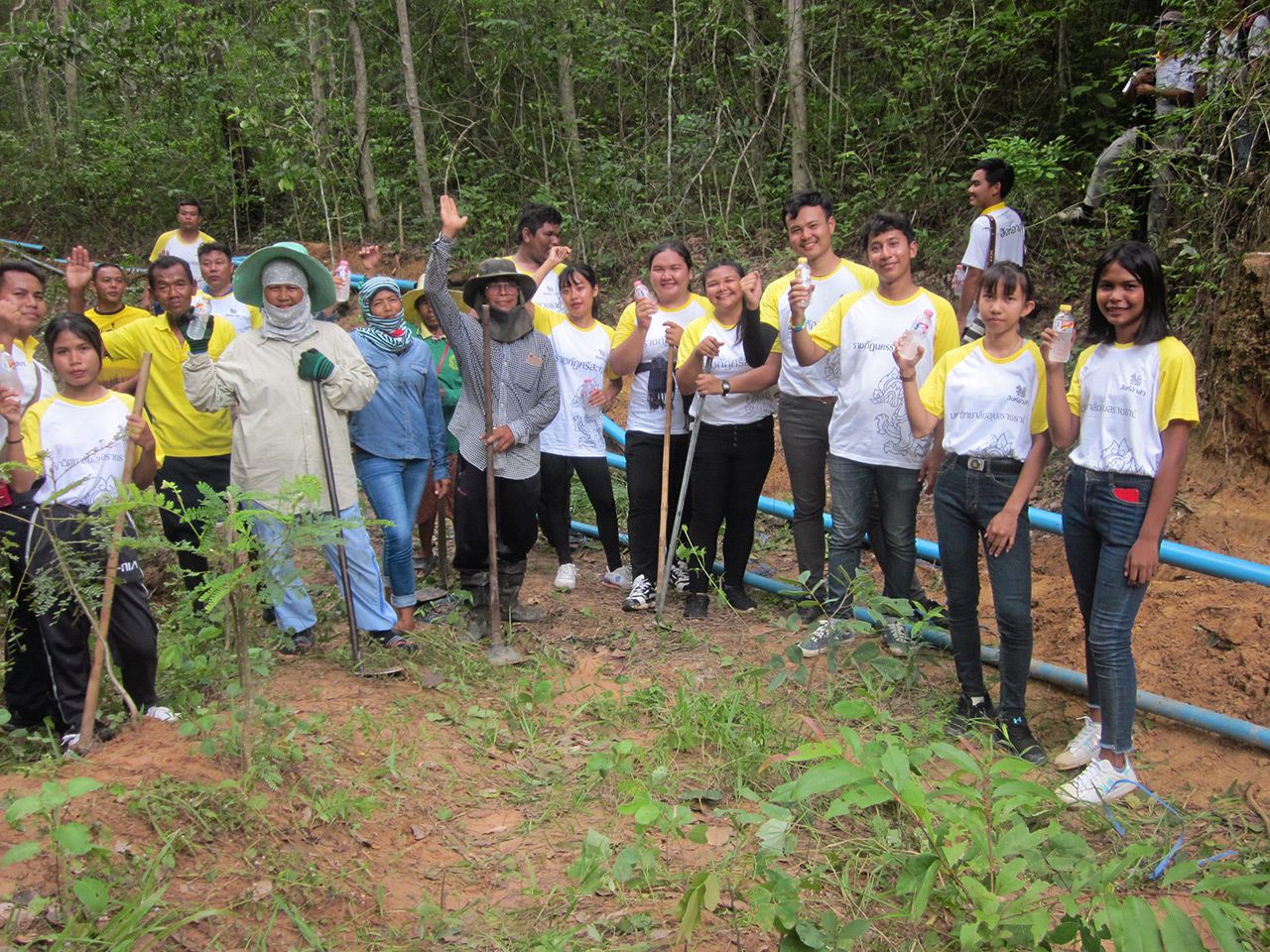 นักศึกษาทีม “สิงห์อาสา” ช่วยกันวางท่อพีวีซีจากแหล่งซับน้ำเชิงเขาพนมดงรัก ไปยังหมู่บ้านกะเลงเวก ต.เทพรักษา อ.สังขะ นำน้ำไปใช้ในหมู่บ้าน.