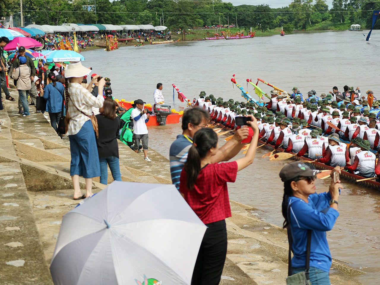 นักท่องเที่ยวพากันถ่ายภาพเรือยาวประเภทต่างๆที่เข้าร่วมการแข่งขัน โดยสองฟากลำน้ำน่านจะคลาคล่ำไปด้วยผู้คนที่เข้าร่วมชมการแข่งขัน.