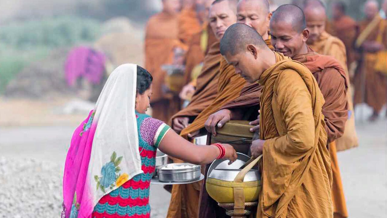 ชาวอินเดียรอใส่บาตรคณะพระธุดงค์จากประเทศไทย ที่เดินตามรอยบาทพระศาสดาสู่สังเวชนียสถาน ด้วยความปลาบปลื้มดีใจ.