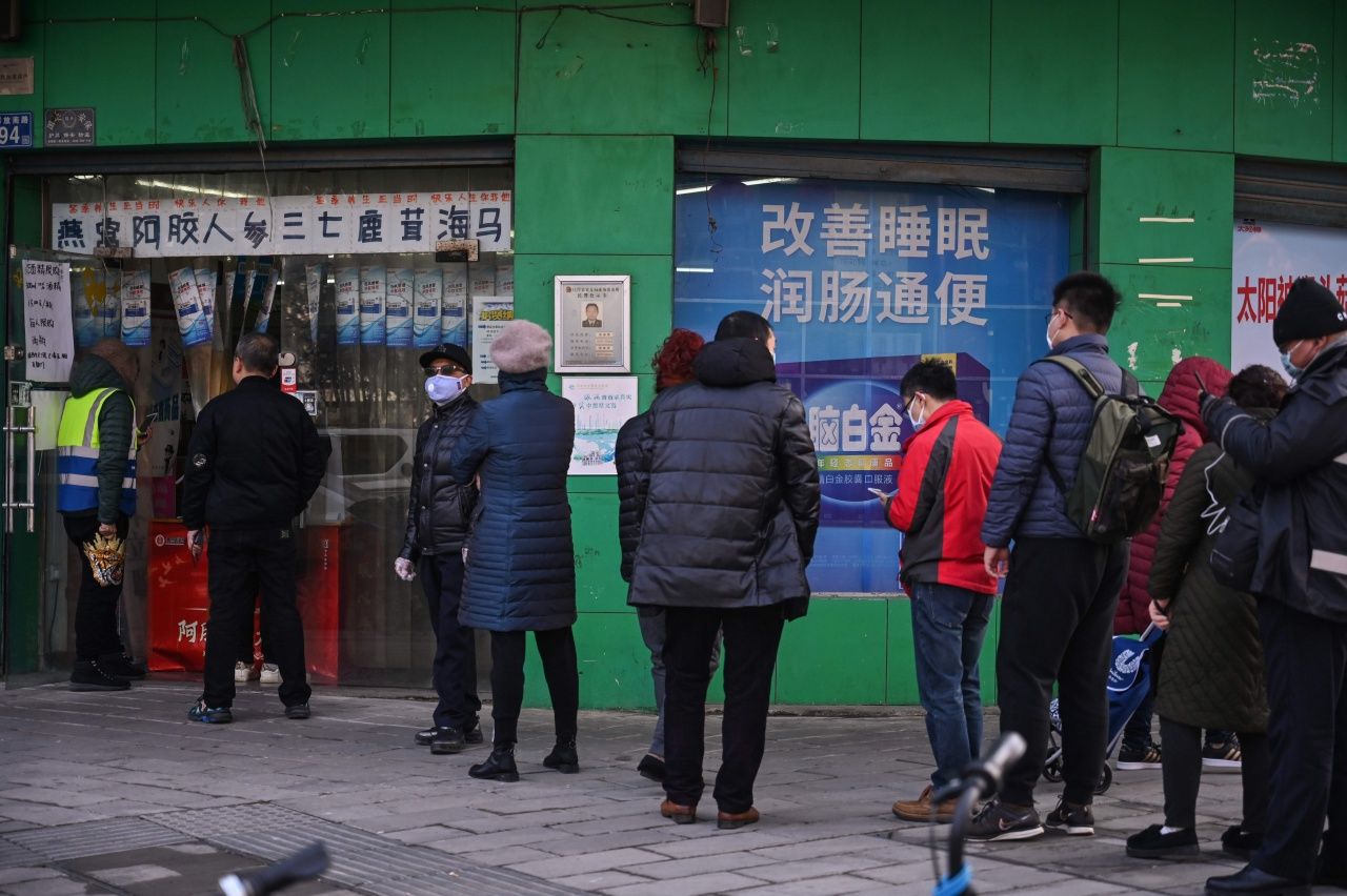 ขาวจีนสวมหน้ากากอนามัยยืนต่อแถวรอซื้อยา-อุปกรณ์เวชภัณฑ์ อยู่ที่หน้าร้านขายยาแห่งหนึ่งในเมืองอู่ฮั่น มณฑลหูเป่ย เมื่อ 30 ม.ค.63