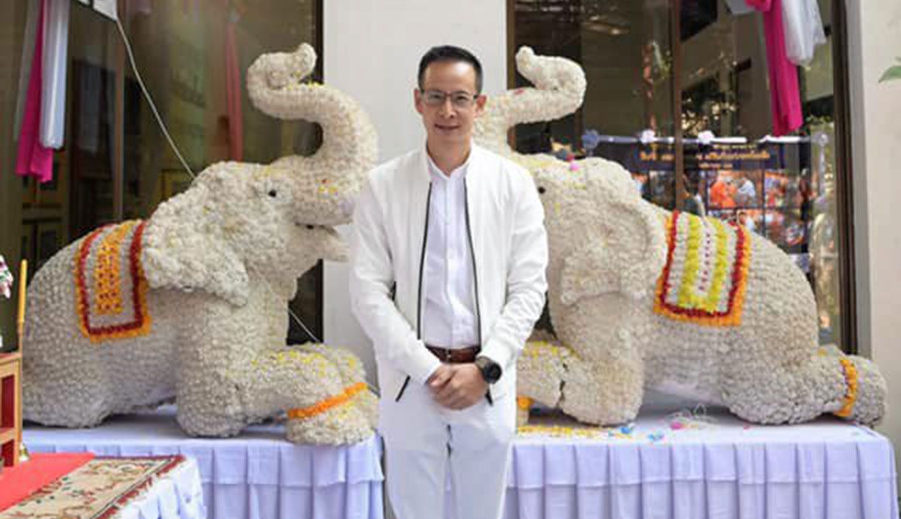 นายสาระ ล่ำซำ กก.ผจก.และประธาน จนท.บห.บมจ.เมืองไทยประกันชีวิต ถ่ายภาพหน้าอาคาร.
