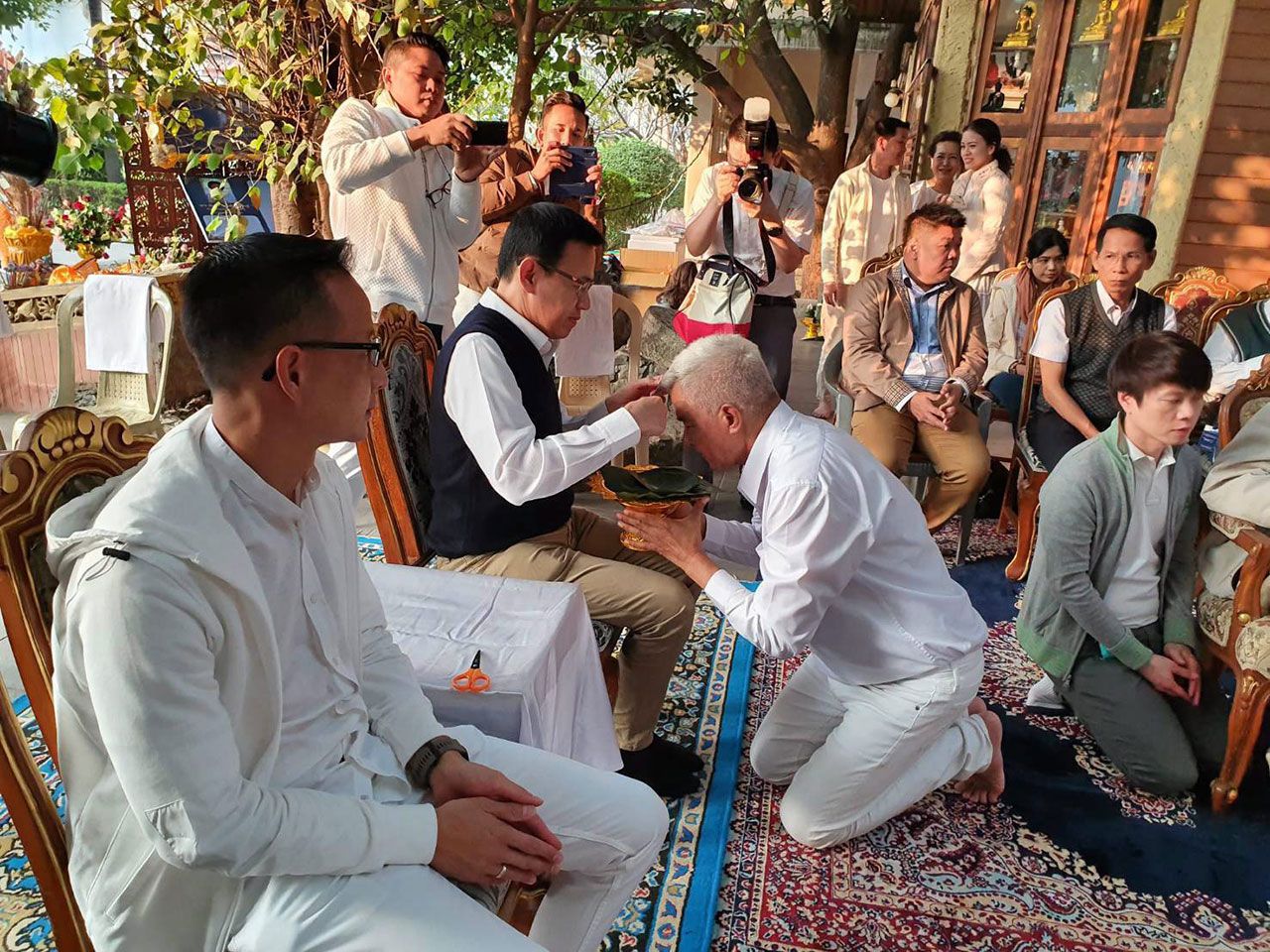 ดร.สุทธิพล ทวีชัยการ เลขาธิการคณะกรรมการส่งเสริมการประกอบธุรกิจประกันภัย ร่วมขลิบผม อ.เผ่าทอง ทองเจือ ก่อนไปบรรพชาใต้ต้นพระศรีมหาโพธิ์.