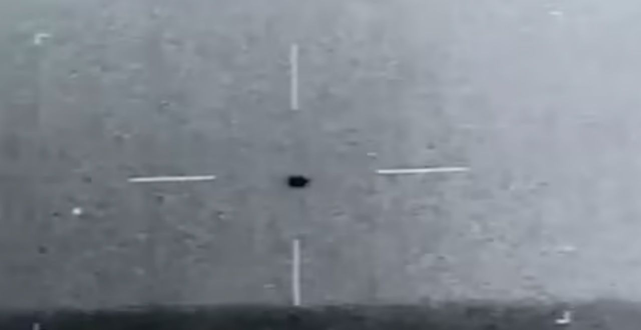 ภาพจากคลิปวิดีโอที่หลุดออกมาสู่สาธารณะ แสดงให้เห็น วัตถุบินที่ไม่สามารถระบุอัตลักษณ์ได้ รูปร่างทรงกลม สีดำ บินอยู่เหนือน้ำทะเล