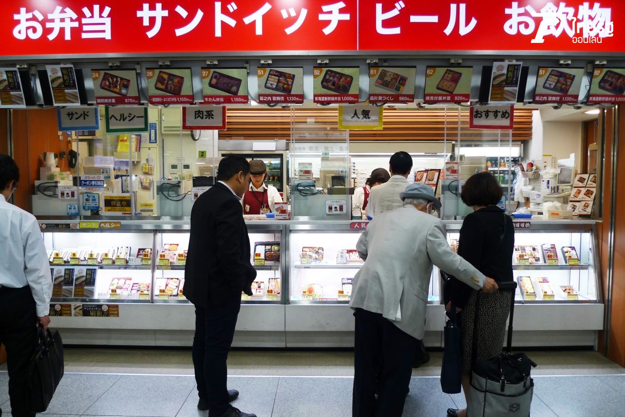 ผู้คนเลือกซื้อหาข้าวกล่องรถไฟและเครื่องดื่มจากร้านภายในสถานีรถไฟก่อนเดินทางไกล